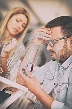 Young frustrated sad man holding wedding engagement ring, proposal rejection