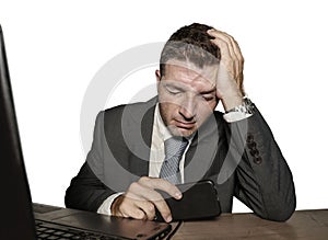 Young frustrated and stressed businessman in suit and tie working overwhelmed at office laptop computer desk desperate and worried