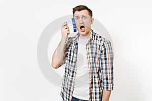 Young fun crazy dizzy loony wild housekeeper man in checkered shirt holding brush for cleaning isolated on white