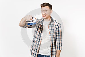 Young fun crazy dizzy loony wild housekeeper man in checkered shirt holding brush for cleaning isolated on white