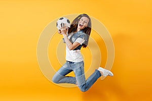 Young fun expressive European woman football fan jumping in air, cheer up support team, holding soccer ball isolated on