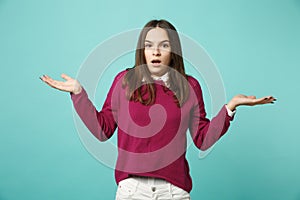 Young fun sad upset perplexed disturb brunette woman girl in red casual clothes posing spreading hands isolated on blue