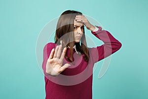 Young fun sad upset perplexed disturb brunette woman girl showing stop gesture with palm posing isolated on blue wall