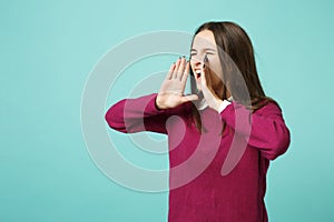 Young fun upset perplexed disturb brunette woman girl scream with hand at mouth posing isolated on blue wall background