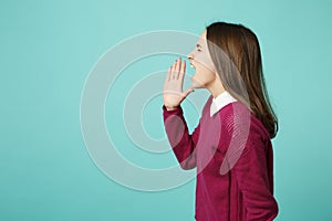 Young fun upset perplexed disturb brunette woman girl scream with hand at mouth posing isolated on blue wall background