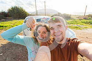 Young funny couple with keys to new car outdoor photo