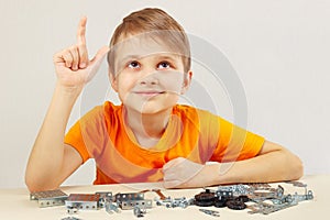 Young funny engineer thinks that assemble from mechanical constructor