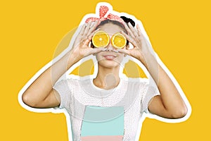 Young funny girl with pink bow on her head holds orange slices on place of her eyes on the orange background