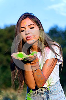 Young funny girl playing with Holi paints