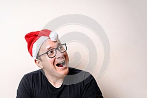 Young funny guy with christmas hat on white background. Sad santa. Christmas