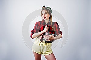 Young funny housewife in checkered shirt and yellow shorts pin up style