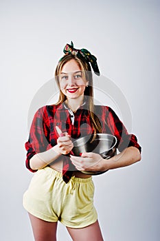 Young funny housewife in checkered shirt and yellow shorts pin up style