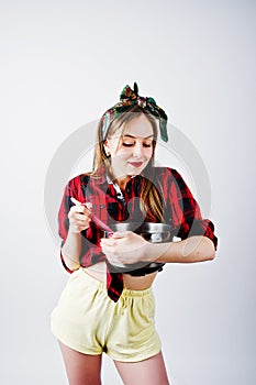 Young funny housewife in checkered shirt and yellow shorts pin up style