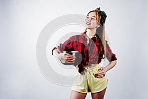 Young funny housewife in checkered shirt and yellow shorts pin up style