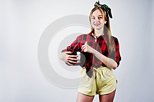 Young funny housewife in checkered shirt and yellow shorts pin up style