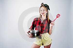 Young funny housewife in checkered shirt and yellow shorts pin up style
