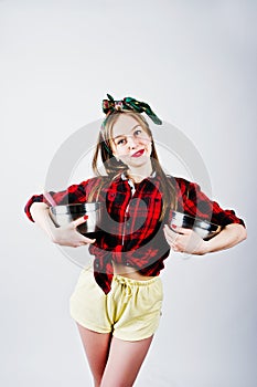 Young funny housewife in checkered shirt and yellow shorts pin up style