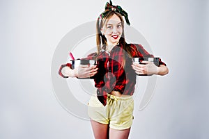 Young funny housewife in checkered shirt and yellow shorts pin up style