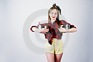 Young funny housewife in checkered shirt and yellow shorts pin up style