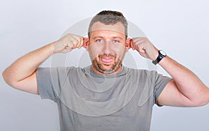 Young funny man holding his ears