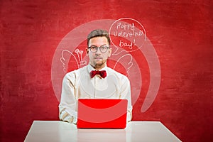 Young funny man with laptop at St. Valentine`s Day