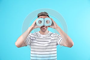 Young funny man looking through toilet paper