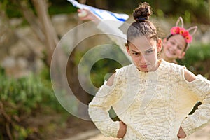 Young funny teenager girl standing outdoor with arms akimbo.