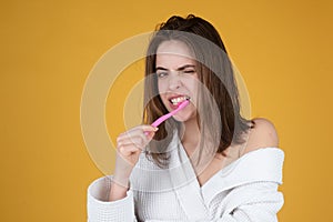 Young funny woman brushing teeth. Happy funny girl brush her teeth on isolated background. Beautiful wide smile of young