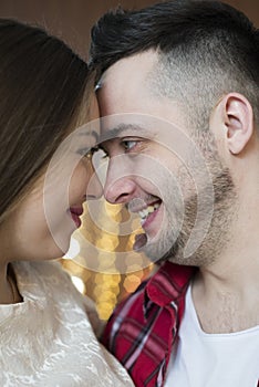 Young future parents on the background of bright lights of garlands.