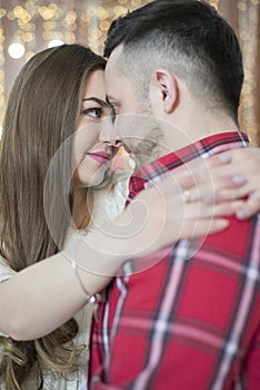 Young future parents on the background of bright lights of garlands.