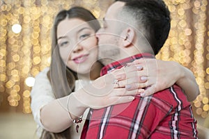 Young future parents on the background of bright lights of garlands.