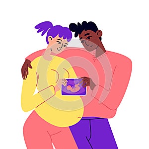 Young future parents are holding a snapshot of the unborn child. A happy pregnant woman stands hugging her husband after an