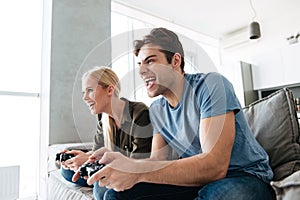 Young gambled lovers playing video games at home