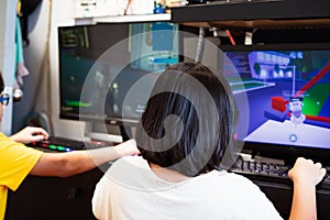 A young gamer girl at home in a room with brother playing with friends on the networks in computer video games