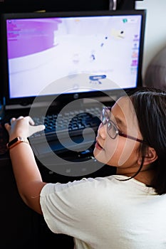 A young gamer girl at home in a room playing with friends on the networks in computer video games