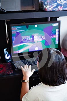 A young gamer girl at home in a room playing with friends on the networks in computer video games