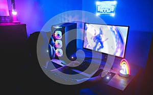 Young gamer playing online platform with neon lights in background - Male guy having fun gaming and streaming in internet with pc photo