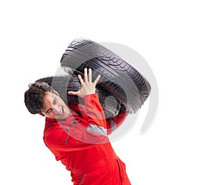 Young garage worker with tyre isolated on white