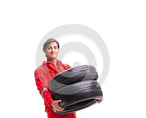 Young garage worker with tyre isolated on white