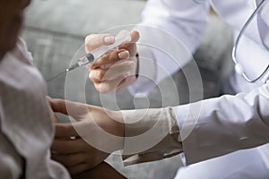 Young general practitioner is making vaccination injection photo