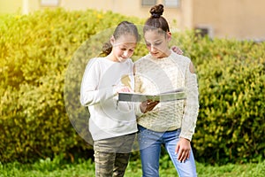 Young Generation.Two Happy Girls Reading A Book Together At Sunny Day.