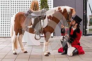 Young gentleman with top hat and his pony show their trained ski