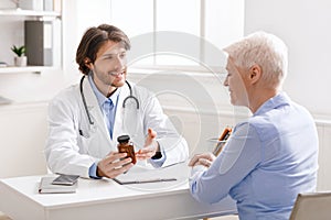 Young geriatrician explaining pills schedule to senior woman