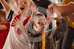 Young German football fans celebrating their team& x27;s victory at stadium.