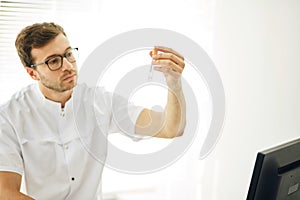 Young gifted man analyzing the content of the tube