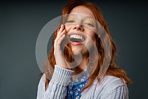Young ginger joyful woman laughing and looking at camera
