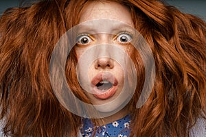 Young ginger shock woman with makeup expressing surprise at camera