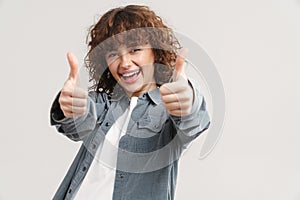 Young ginger woman in shirt smiling and showing thumb up