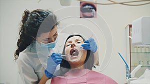 A young girl is admitted to a dentist. During this time she opens her mouth and understands the doctor.