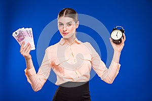 Young girl with an alarm clock and money
